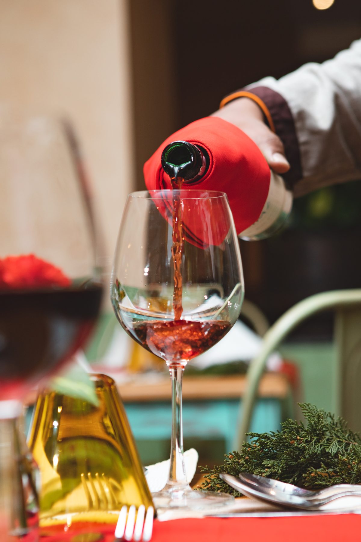 Red wine poured into a glass by a server at Jharana Bar