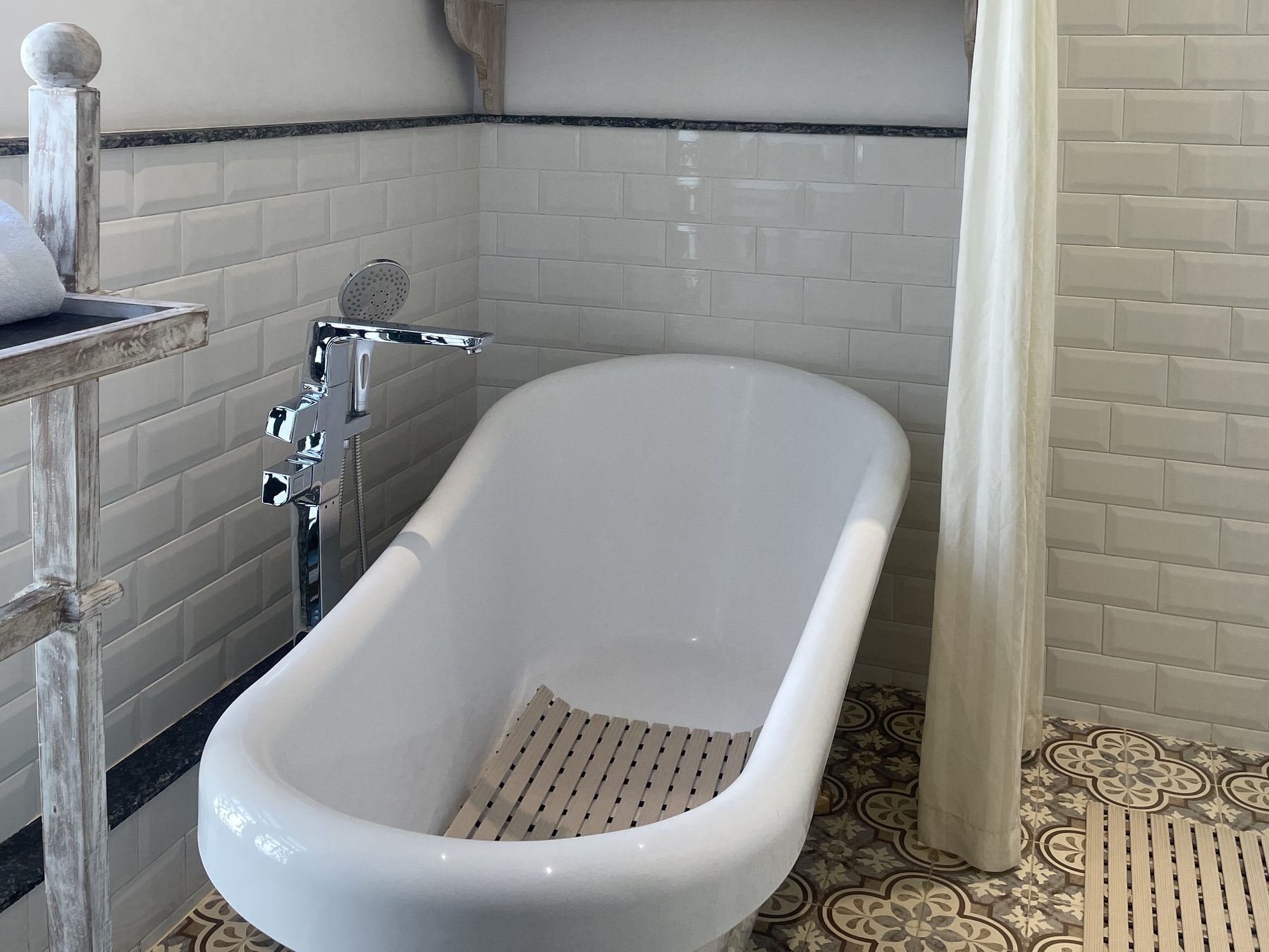 Freestanding clawfoot bathtub in the Classic Junior Suite bathroom with patterned tile floor