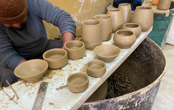A potter shaping the refillable clay amenity pots used across Nepali Ghar